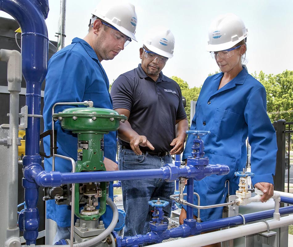 Workers at Chemical Plant looking at pipes