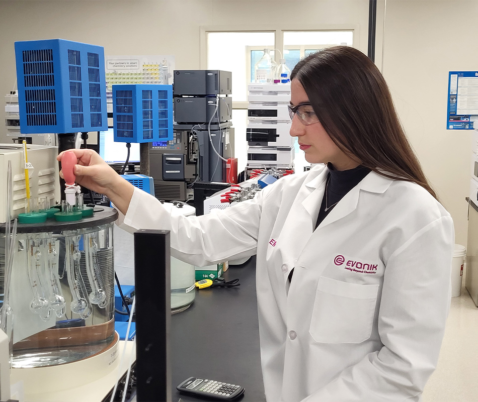 Woman with lab coat running tests at Evonik